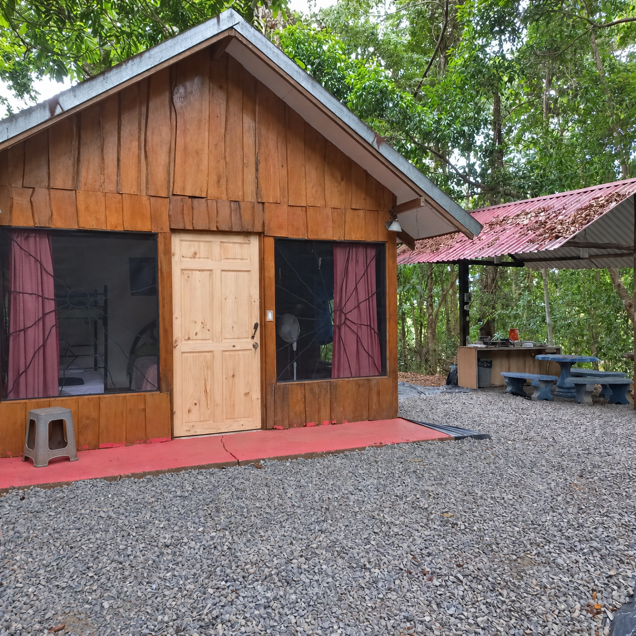Cabaña de madera y área de cocina exterior en La Ceiba