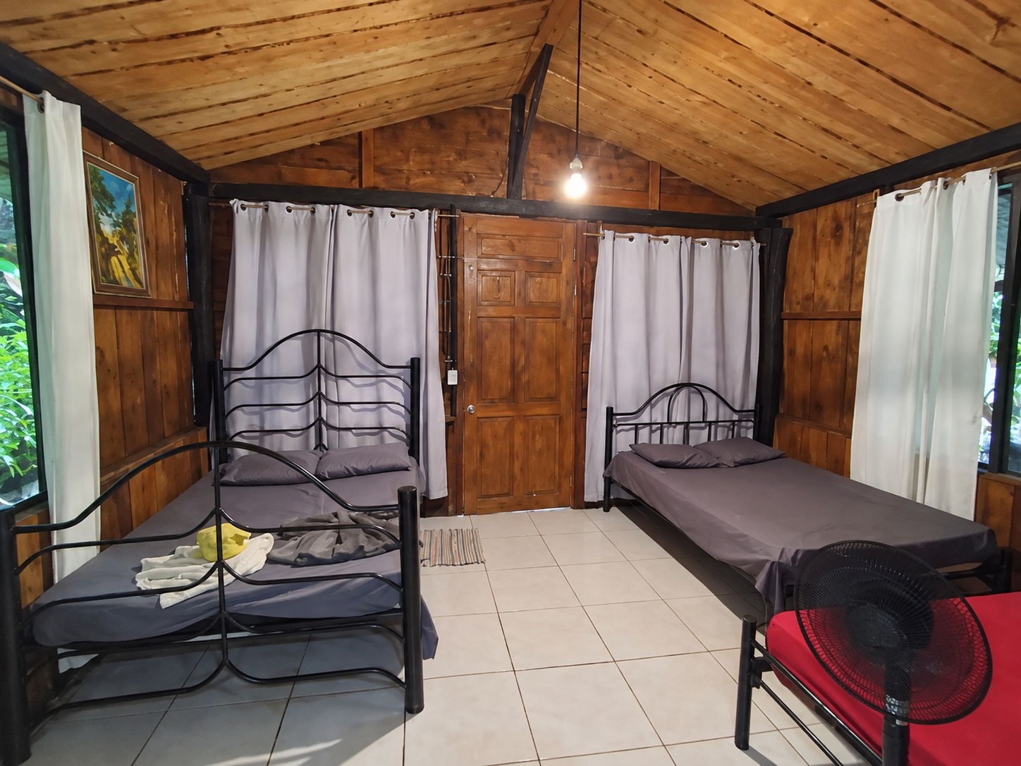 Interior de madera con dos camas y techo alto
